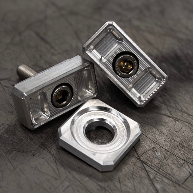Billet Dyna axle adjuster blocks with stainless steel hardware and a specialty washer
